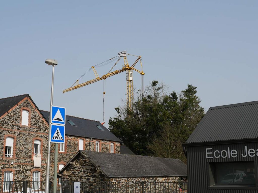 Derrière l'école Jeanne d'Arc, à guipry, un drapeau breton flotte en haut d'une grue.