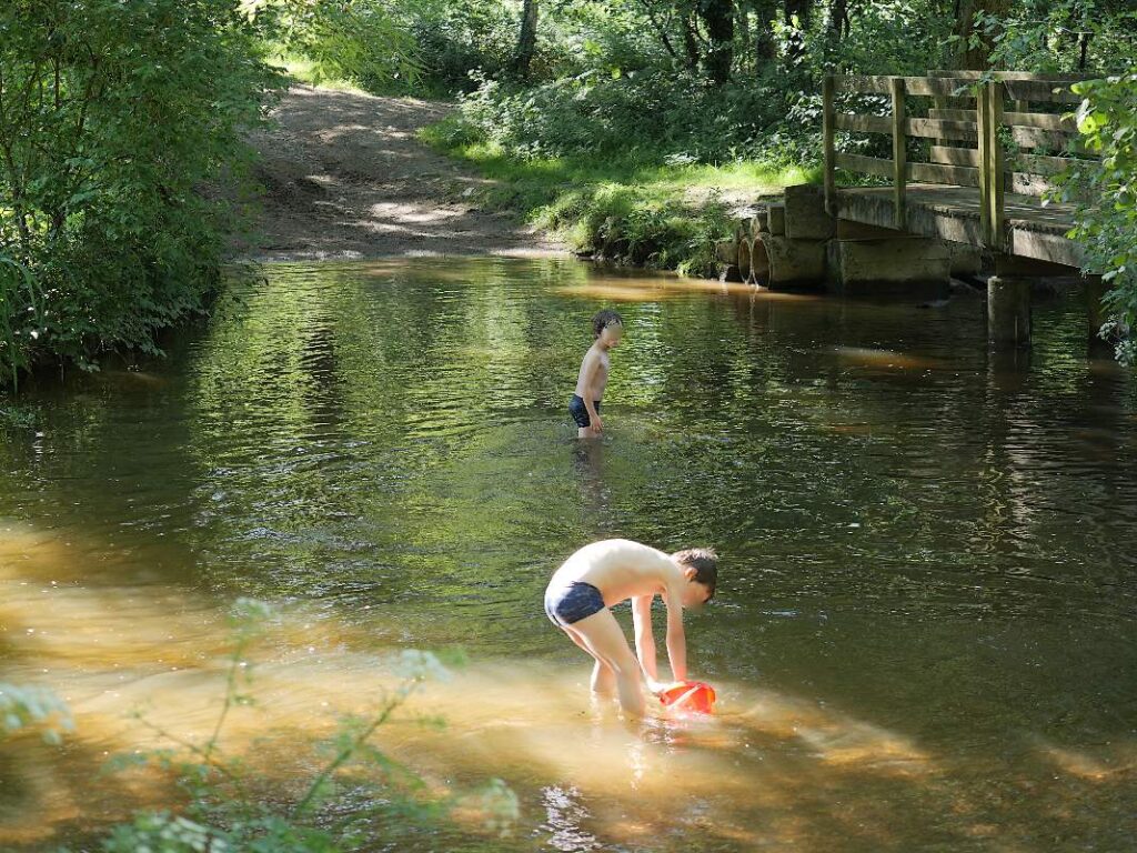 Deux enfants jouent dans l'eau au gué de Trohinat