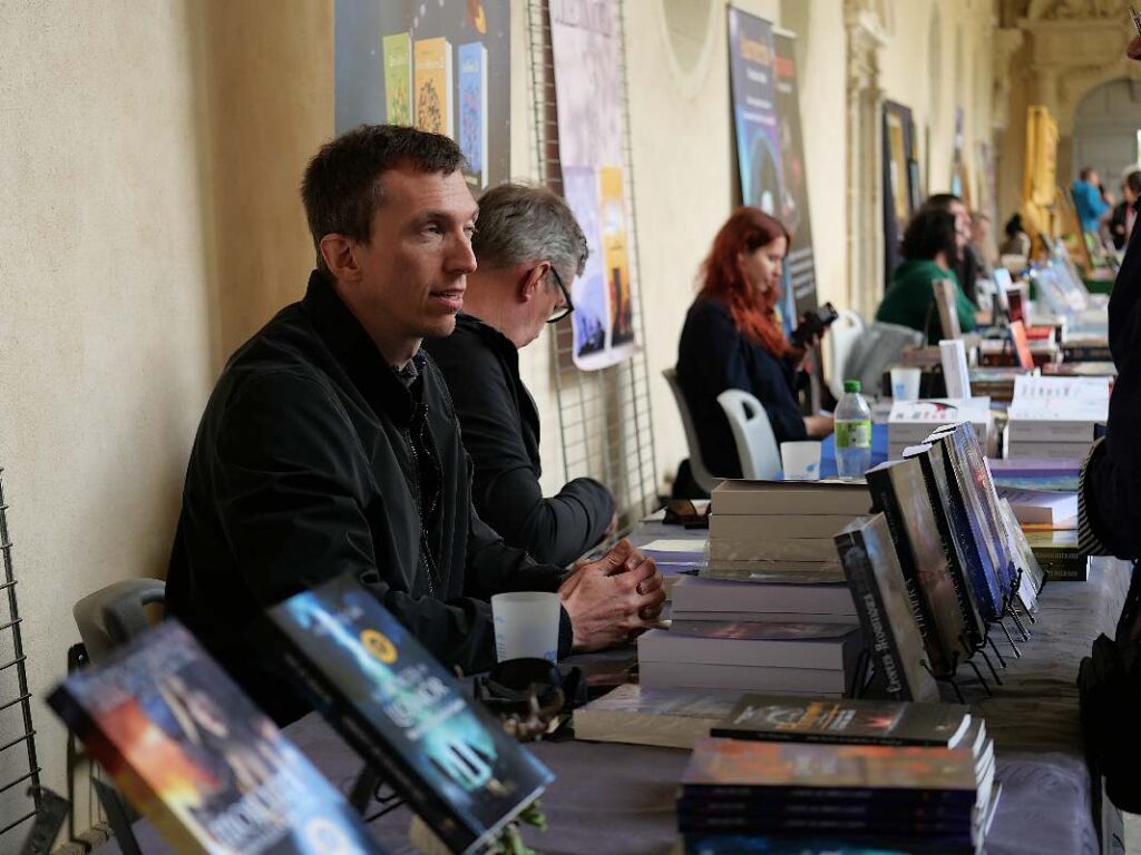 Dans le cloître Saint-Sauveur, écrivains et éditeurs présentent des livres.